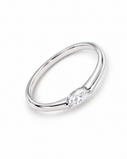 The Aure Marquise-Cut CZ Ring, polished silver overhead diagonal resting-lay view on a pearl-white studio background — reference-based AI visualization.