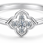 The Seren Quatrefoil Moissanite Ring in visible silver-tone finish, close studio detail of the open four-lobed setting and clear five-stone cluster on a pearl-white background, reference-based AI visualization.