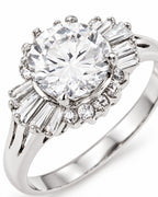 Macro view of The Elian CZ Baguette Ring in polished silver-toned finish, showing the clear round center stone, four-prong setting and baguette accents on a pearl-white studio background — reference-based AI visualization.