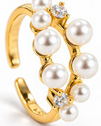 The Ilse Pearl Cluster Ring in observed gold finish, close macro view of ivory pearl-like cabochons, clear round faceted accents, and petite gold prong settings on a pearl-white background; reference-based AI visualization.