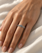 The Runa Starburst Ring — bright silver-tone starburst ring worn on a medium-warm adult hand over ivory linen in warm window light; reference-based AI visualization.