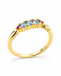 The Miri Color-Accent Band with a polished yellow-gold-colored band, three light-blue round stones and two magenta round accent stones, complete front three-quarter product-only view on a pearl-white studio background, reference-based AI visualization