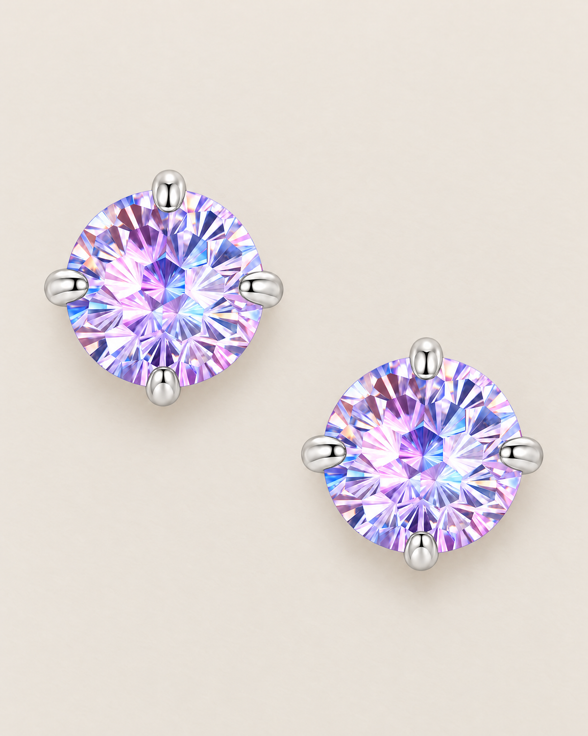 The Frida Firework CZ Stud Earrings: separated overhead pair of purple-lilac faceted round studs in four polished cool silver-tone prongs on pale greige, reference-based AI visualization
