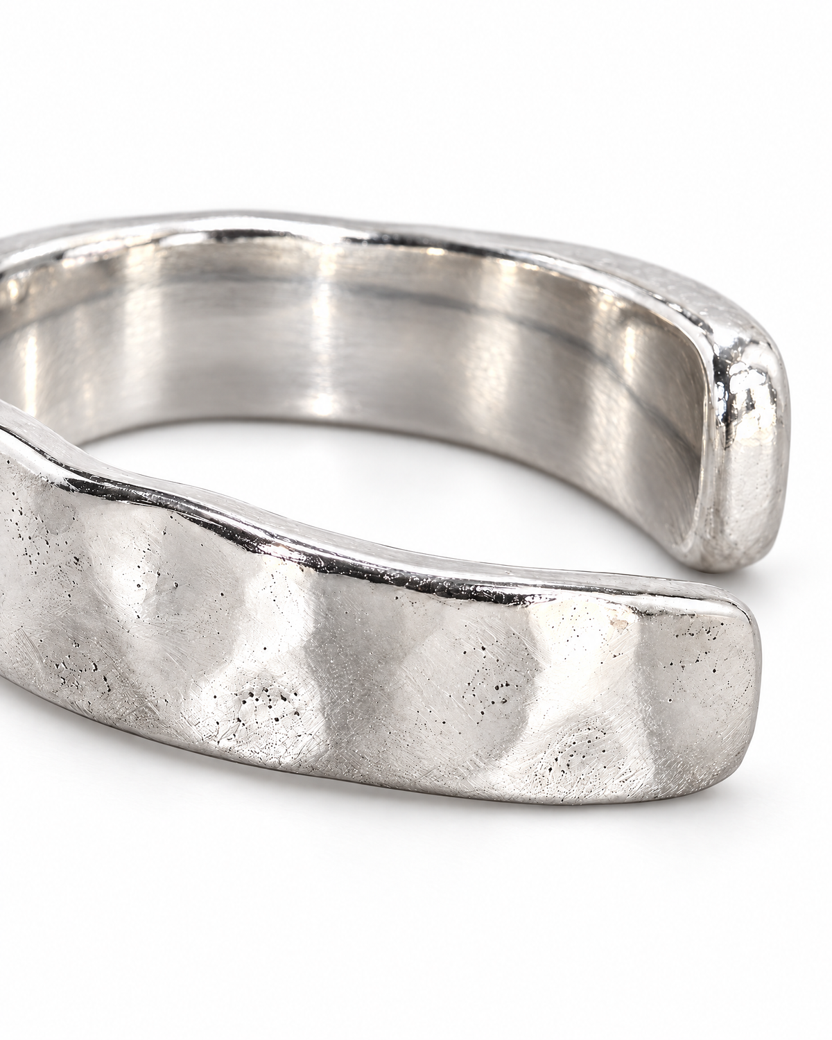 The Lena Hammered Open Band Ring — polished silver-tone hammered exterior and rounded open-end macro on a pearl-white studio background, reference-based AI visualization.