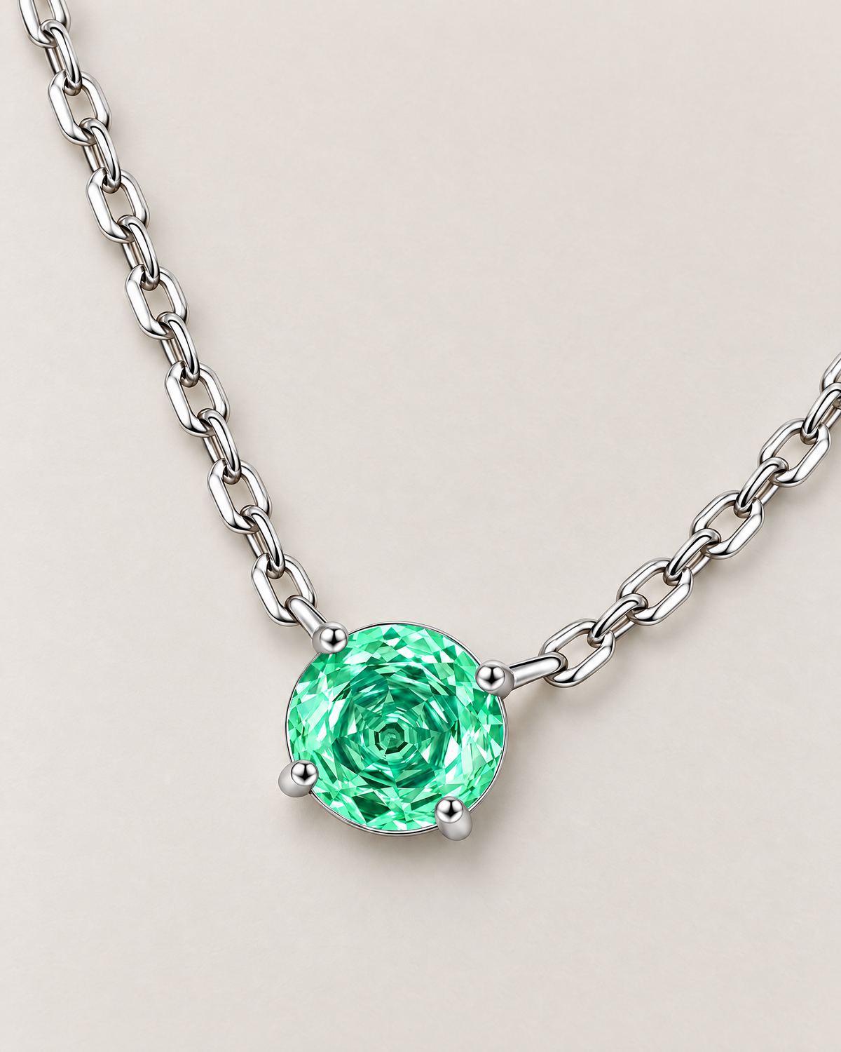 Round green faceted pendant in a silver-colored four-prong setting with linked chain arranged on a diagonal pale greige studio ground — reference-based AI visualization