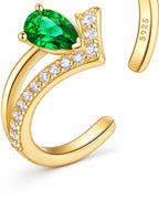 Macro view of The Tuva Green Pear Wrap Ring in polished gold-color metal with a green pear-shaped stone, clear round accents, and visible S925 engraving on a pearl-white studio background, reference-based AI visualization