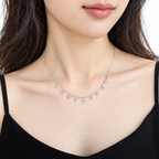 The Astrid CZ Link Necklace — silver-tone CZ charm necklace, alternate worn front view in white studio; reference-based AI visualization.