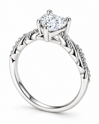 The Alva Heart-Stone Ring, observed polished silver-tone, complete underside setting-depth view of its clear heart-shaped center stone, four rounded prongs, and twisted beaded shoulders on a pearl-white studio background — reference-based AI visualization.
