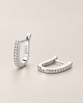 The Aria CZ Hoops — pair of polished silver-colored U-shaped hoops with clear round stone rows, one upright and one resting on pale greige, reference-based AI visualization