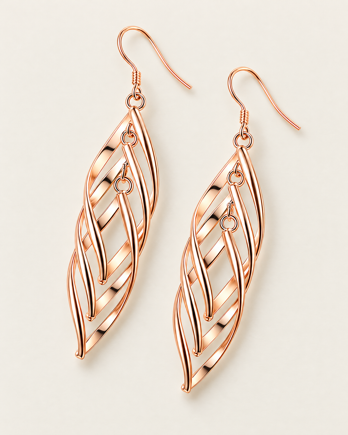 The Sova CZ Drop Earrings — Warm gold-color openwork leaf drop pair in a clean overhead lay on pale greige; reference-based AI visualization