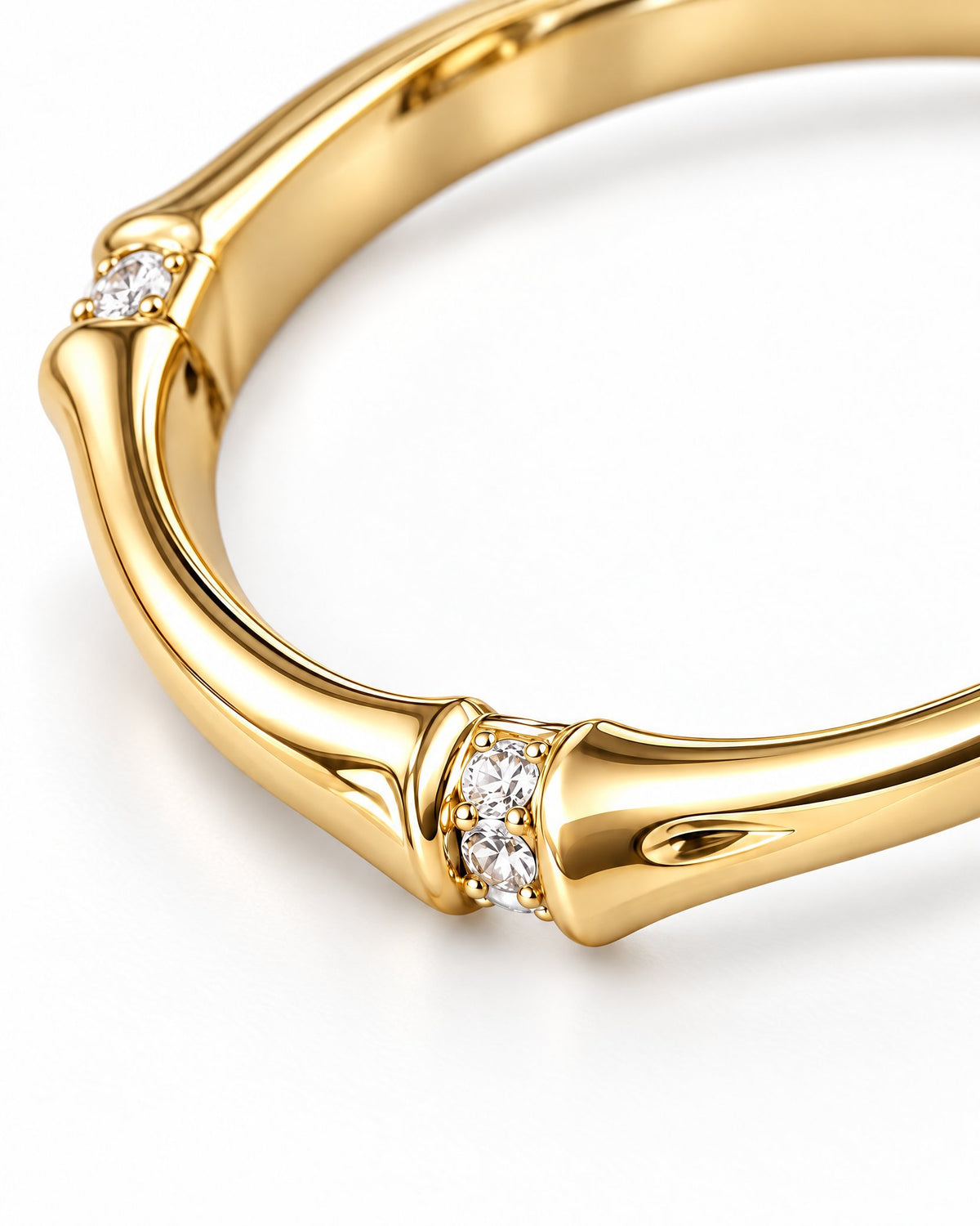 The Ebba Bamboo Band in polished yellow-gold color with clear round stone accents and bamboo-like band detail, macro product-only studio view on a pearl-white background; reference-based AI visualization.