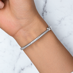 The Maia Pavé Hinge Bangle polished silver-tone pavé-panel detail with clear stones and beaded edges on pale greige, reference-based AI visualization