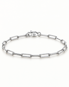 The Aelin Paperclip Bracelet in silver tone, full oval hero on a plain pearl-white studio background; reference-based AI visualization