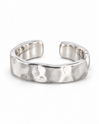 The Lena Hammered Open Band Ring — polished silver-tone front three-quarter product-only hero on a pearl-white studio background, reference-based AI visualization.