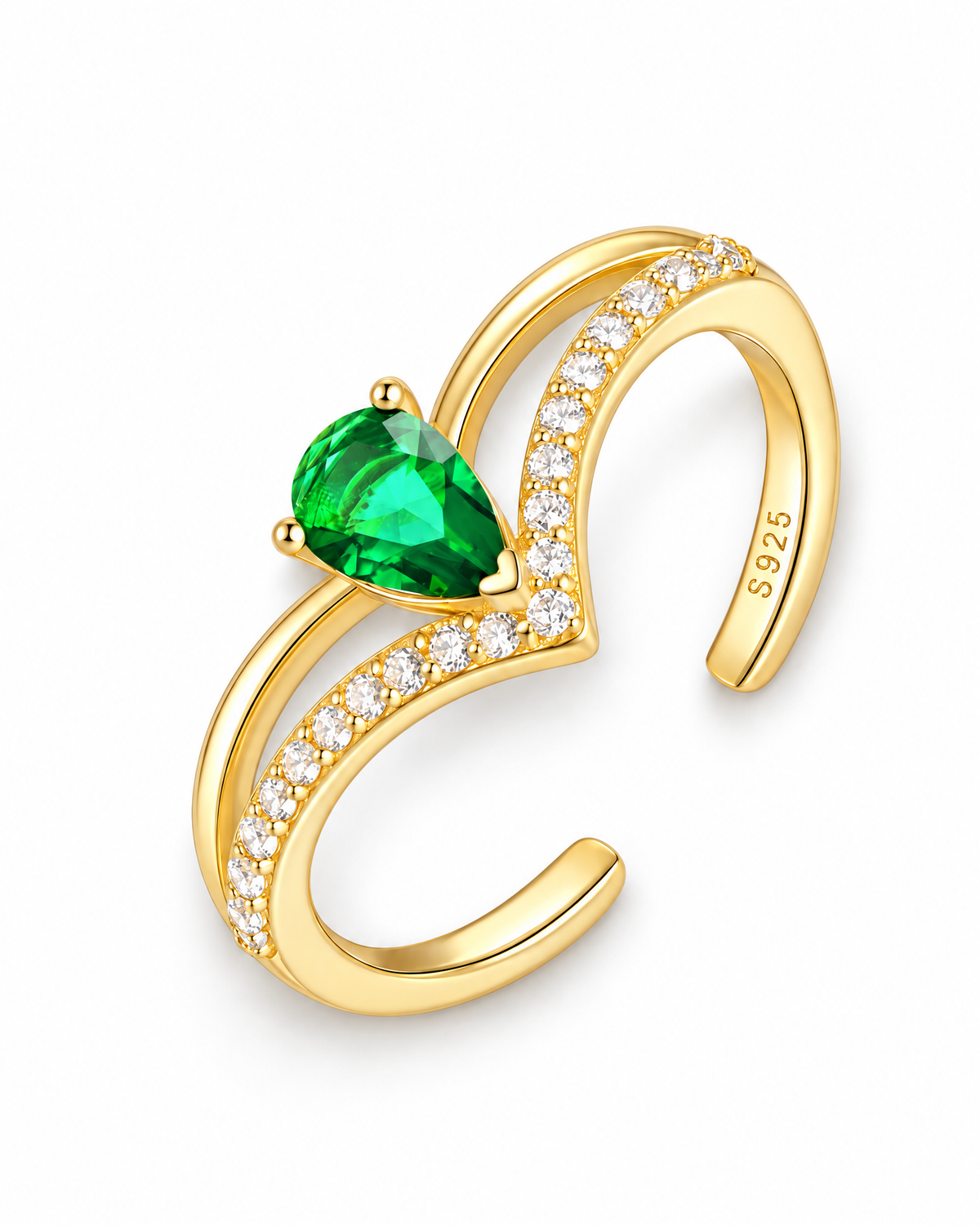 The Tuva Green Pear Wrap Ring in a diagonal overhead flat lay with polished gold-color metal, a green pear-shaped stone, and clear round accents on a pearl-white studio background, reference-based AI visualization