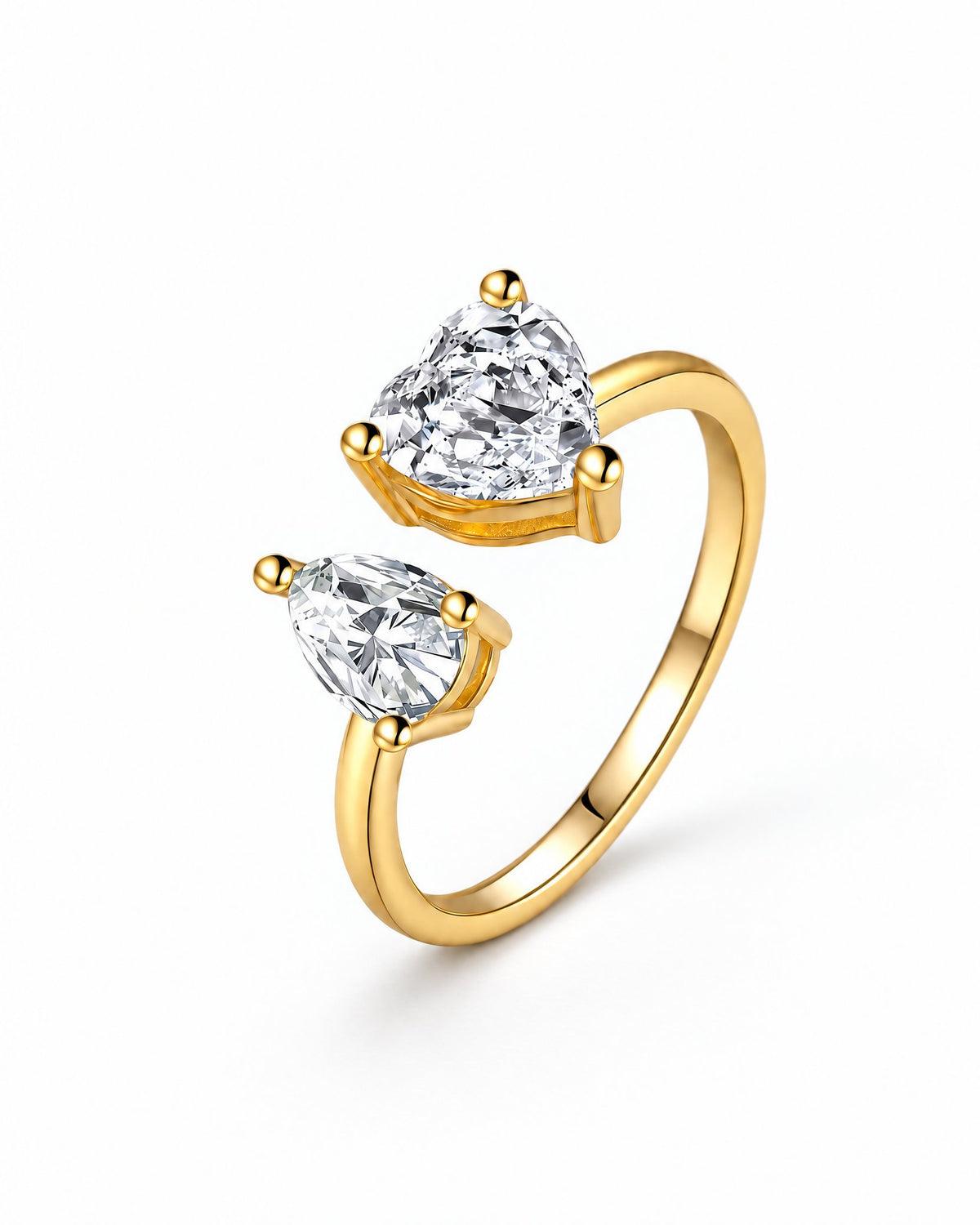 The Nessa Heart & Pear Ring in polished yellow-gold-tone metal with clear faceted heart and pear stones, shown complete in a front three-quarter pearl-white studio view — reference-based AI visualization.
