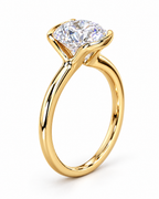 The Astrea Moissanite Solitaire Ring — warm gold-color curved four-prong setting detail on a pearl-white studio background; reference-based AI visualization.