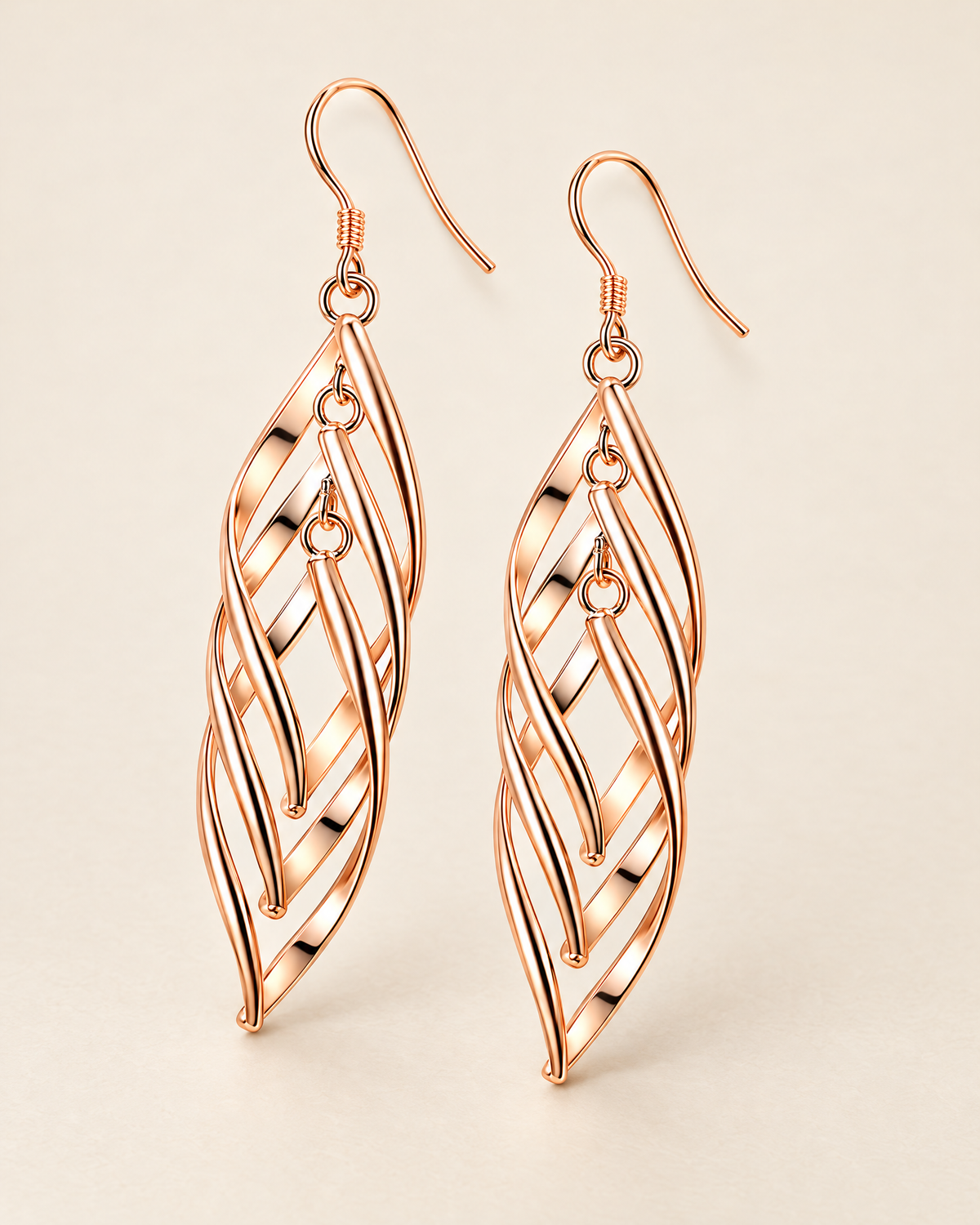 The Sova CZ Drop Earrings — Warm gold-color openwork leaf drop pair in a front three-quarter studio view on pale greige; reference-based AI visualization