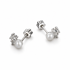 The Elva Pearl & Moissanite Stud Earrings, rear pair view with white pearls, clear round stones, straight posts and scalloped silvery butterfly backs on pale greige, reference-based AI visualization.