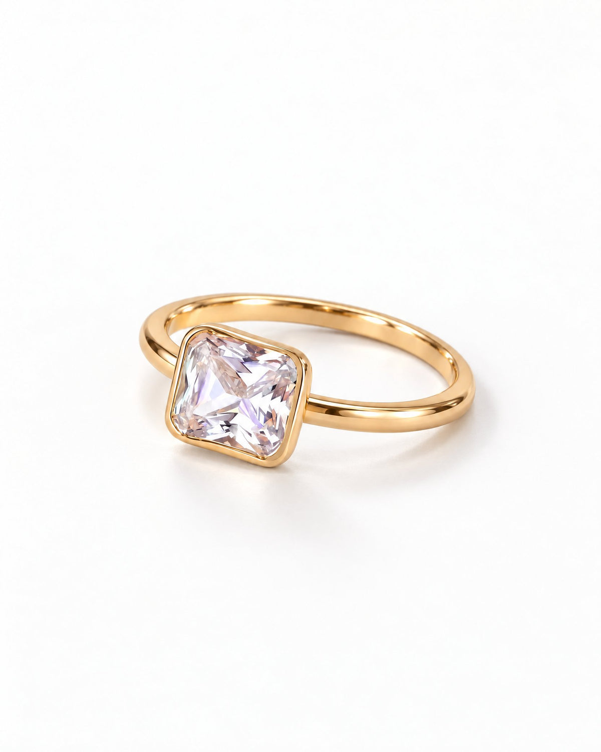 The gold-finish Eira Square Solitaire Ring shown complete at a low flat-lay angle on pearl white, with the single square stone toward the left; reference-based AI visualization.