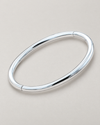 The Talo Open Cuff Bangle — polished silver-tone closed oval diagonal resting lay on pale greige; reference-based AI visualization