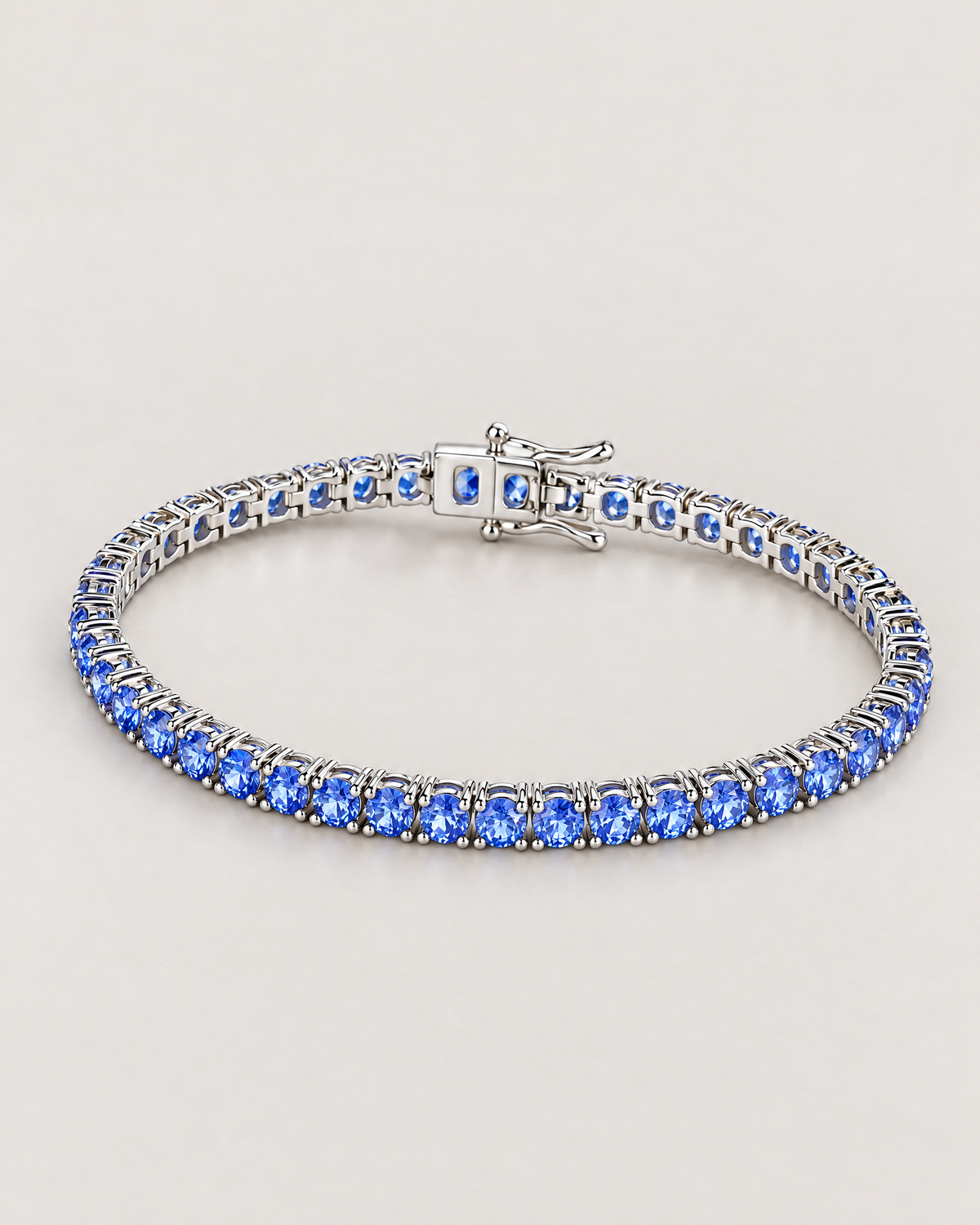 The Orla CZ Tennis Bracelet — complete silver-tone and blue-stone underside resting lay on pale greige — reference-based AI visualization
