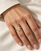 The Esme Bezel-Set Oval Ring in Gold Tone, elegant on-hand view on a light-warm adult hand with ivory linen, reference-based AI visualization.