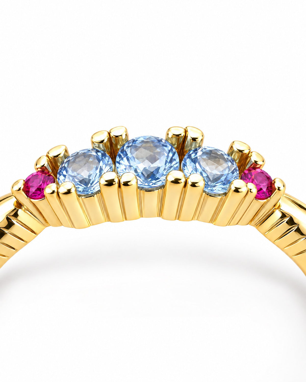 The Miri Color-Accent Band crown in macro detail with a polished yellow-gold-colored setting, three light-blue round stones, two magenta round accent stones and ribbed shoulders on a pearl-white studio background, reference-based AI visualization