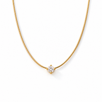 Gold-color necklace detail showing the clear round four-prong stone, segmented chain, lobster clasp, extension links, and smooth end tag on pale warm greige; reference-based AI visualization.