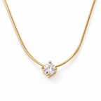 Gold-color necklace in a continuous flowing asymmetric S lay with a clear round four-prong stone, lobster clasp, extension links, and smooth end tag on pale warm greige; reference-based AI visualization.