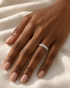 The Klint CZ Pavé Band — polished silver-tone pavé band worn on a deep-brown-skinned adult hand over ivory linen; reference-based AI visualization.