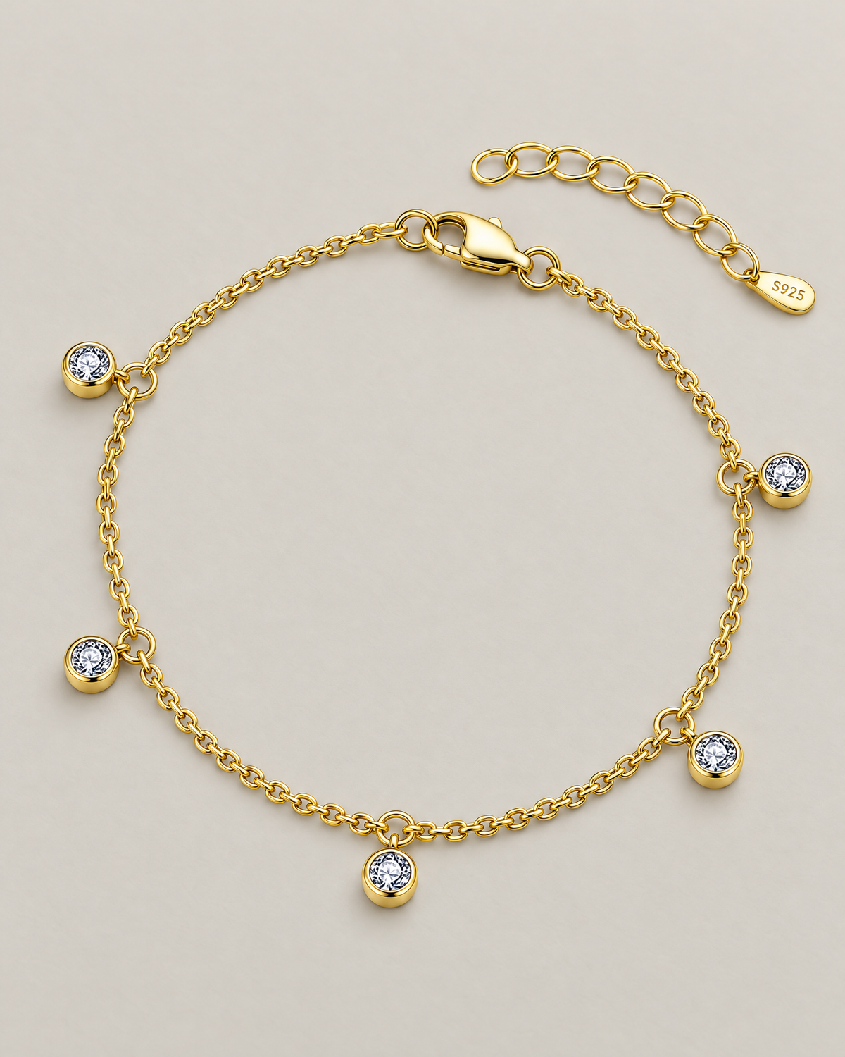 The Helle Moissanite Station Bracelet in gold tone, shown as a full five-station diagonal oval lay on pale greige, reference-based AI visualization.