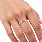 The Veda CZ Twisted Band — polished silver twisted band with clear round CZ accents worn on a medium-warm-skinned adult hand against ivory linen; reference-based AI visualization.