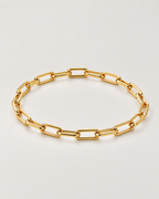 The Linnea Link Bracelet — polished gold-color rounded paperclip-link oval on pale greige — reference-based AI visualization