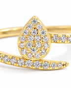 The Oona Pavé Teardrop Ring in warm polished gold with clear round pavé stones, teardrop-setting macro on a pearl-white studio background; reference-based AI visualization.