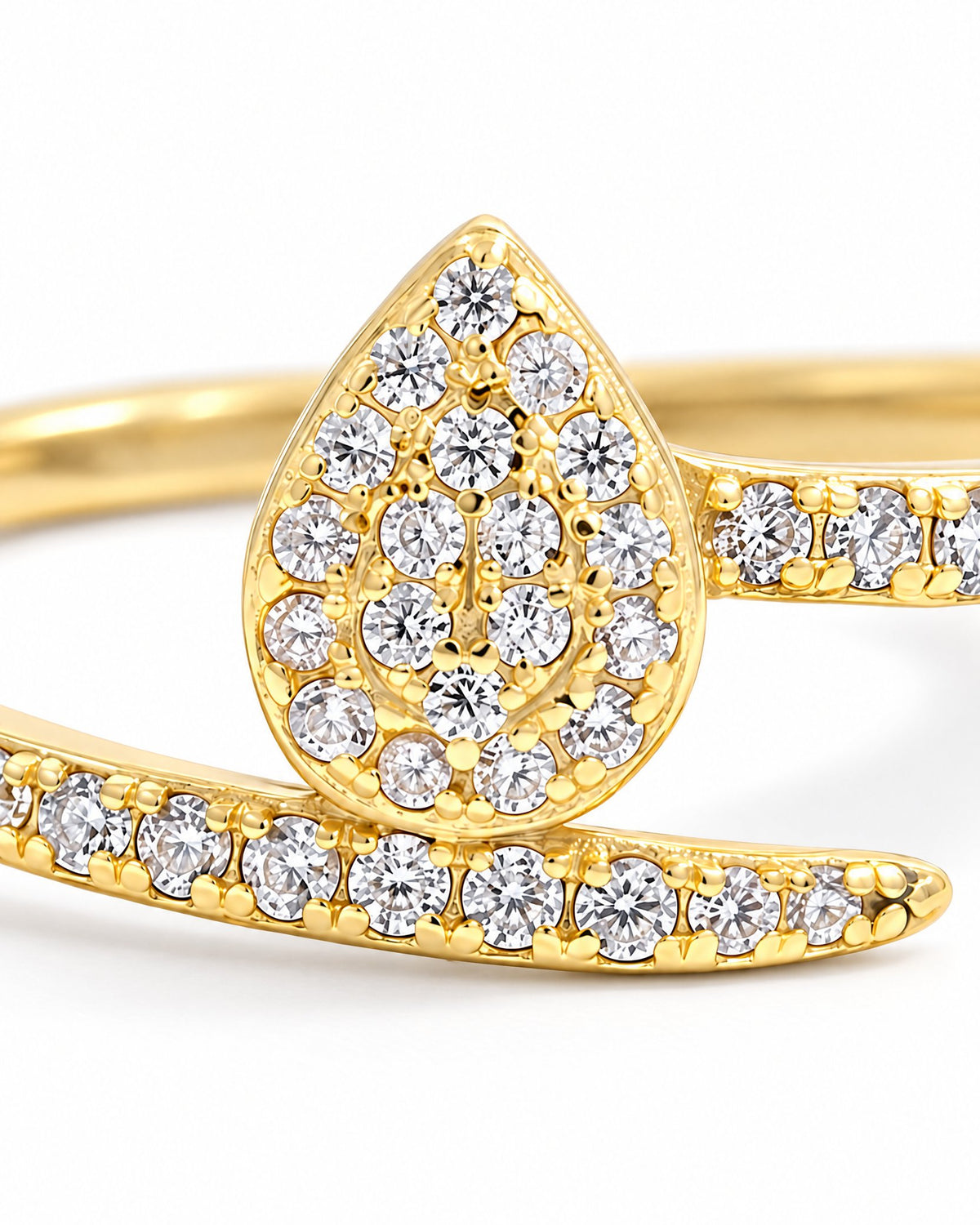 The Oona Pavé Teardrop Ring in warm polished gold with clear round pavé stones, teardrop-setting macro on a pearl-white studio background; reference-based AI visualization.