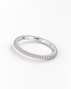 The Vale CZ Eternity Band — bright polished silver-tone clear-stone eternity band in a low resting profile on a pearl-white studio background, reference-based AI visualization
