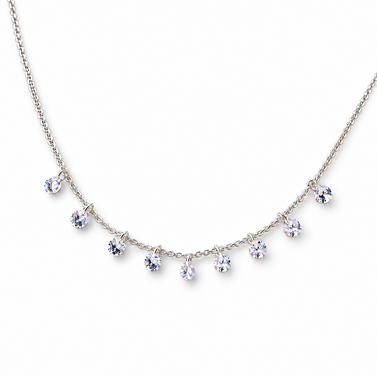 The Astrid CZ Link Necklace — silver-tone CZ charm necklace, tabletop front view in white studio; reference-based AI visualization.