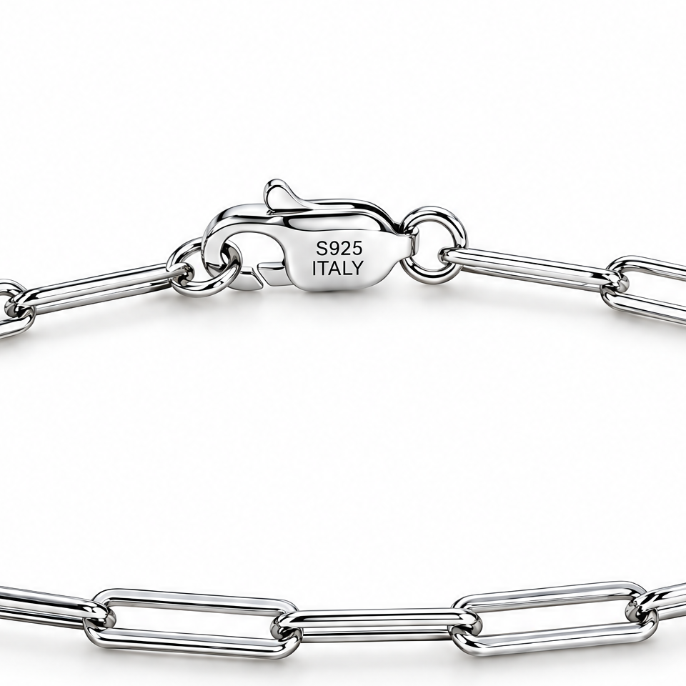 The Aelin Paperclip Bracelet in polished silver tone, macro view of the clasp with visible S925 ITALY marking and adjacent paperclip links on plain pearl-white studio background; reference-based AI visualization