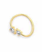 The Agnes Twin-Pear Ring in a polished yellow-gold finish with two clear pear-shaped stones, rotated whole-ring overhead view on a pearl-white studio background — reference-based AI visualization