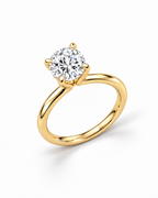 The Astrea Moissanite Solitaire Ring — warm gold-color overhead diagonal solitaire view on a pearl-white studio background; reference-based AI visualization.