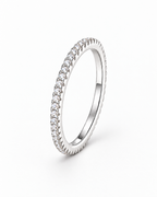 The Vale CZ Eternity Band — bright polished silver-tone clear-stone eternity band, front three-quarter product-only hero on a pearl-white studio background, reference-based AI visualization