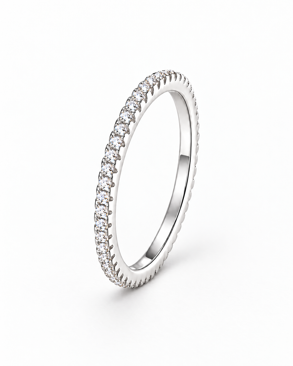 The Vale CZ Eternity Band — bright polished silver-tone clear-stone eternity band, front three-quarter product-only hero on a pearl-white studio background, reference-based AI visualization