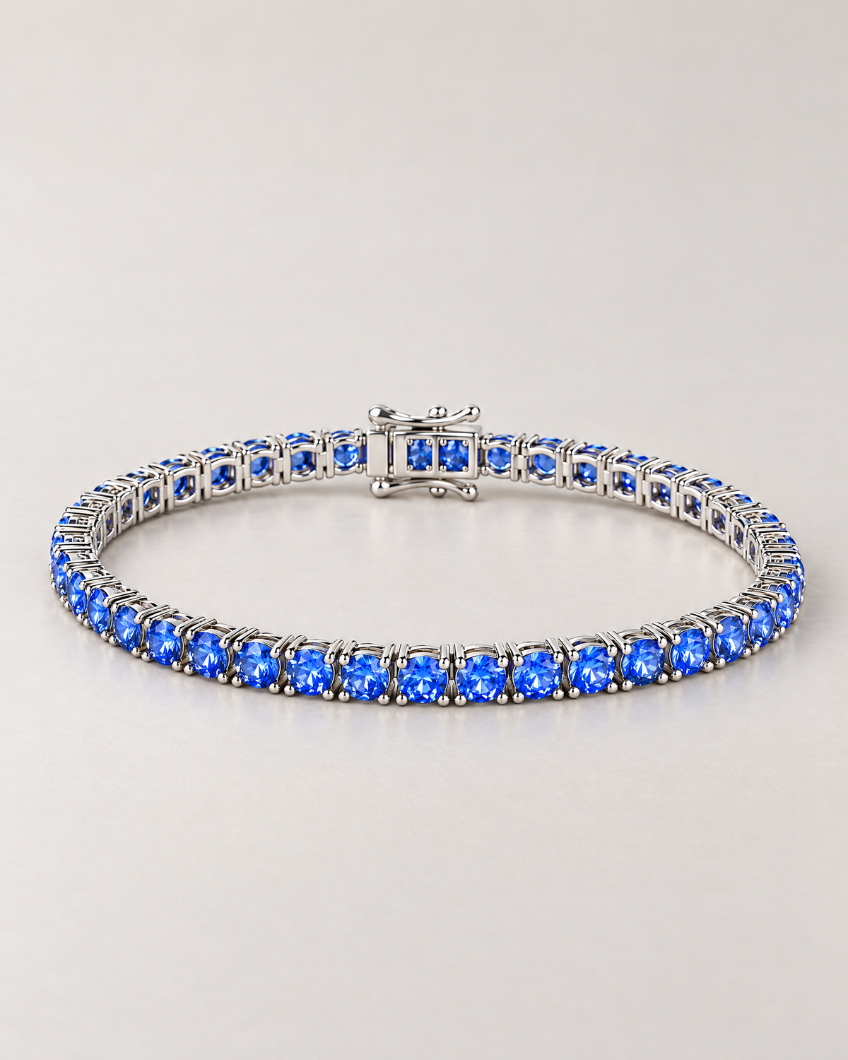 The Orla CZ Tennis Bracelet — complete low-angle silver-tone blue-stone tennis bracelet on pale greige — reference-based AI visualization