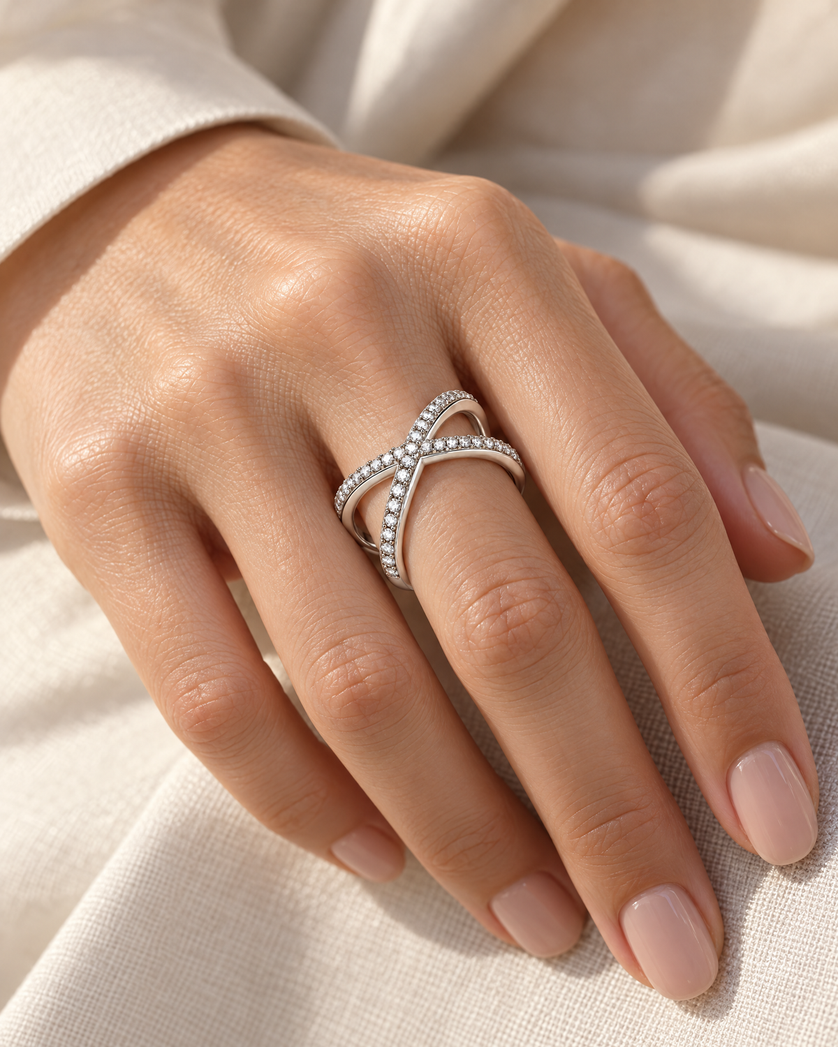 The Elsen Geometric Ring in a polished silver-tone finish with clear round stones, correctly worn on an adult woman's hand over ivory linen, reference-based AI visualization