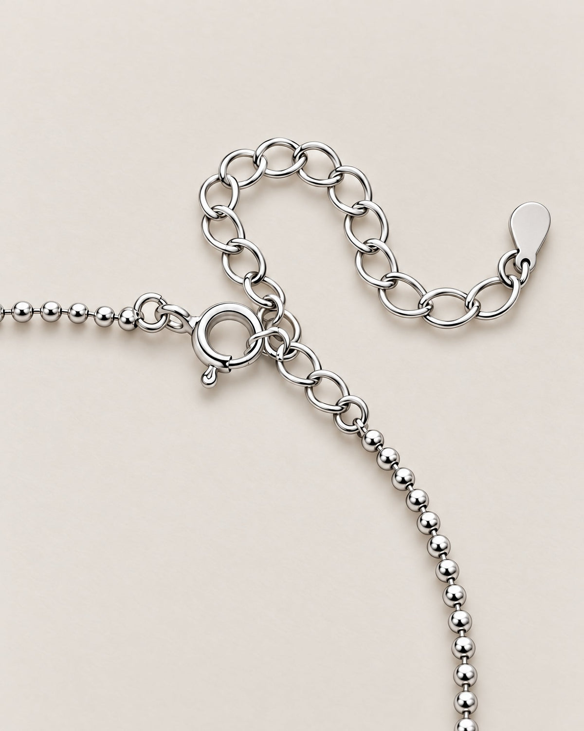 The Eden Moissanite Bracelet silver-tone spring-ring clasp, ball-bead chain, and oval-link extension detail on a pale-greige background, reference-based AI visualization.
