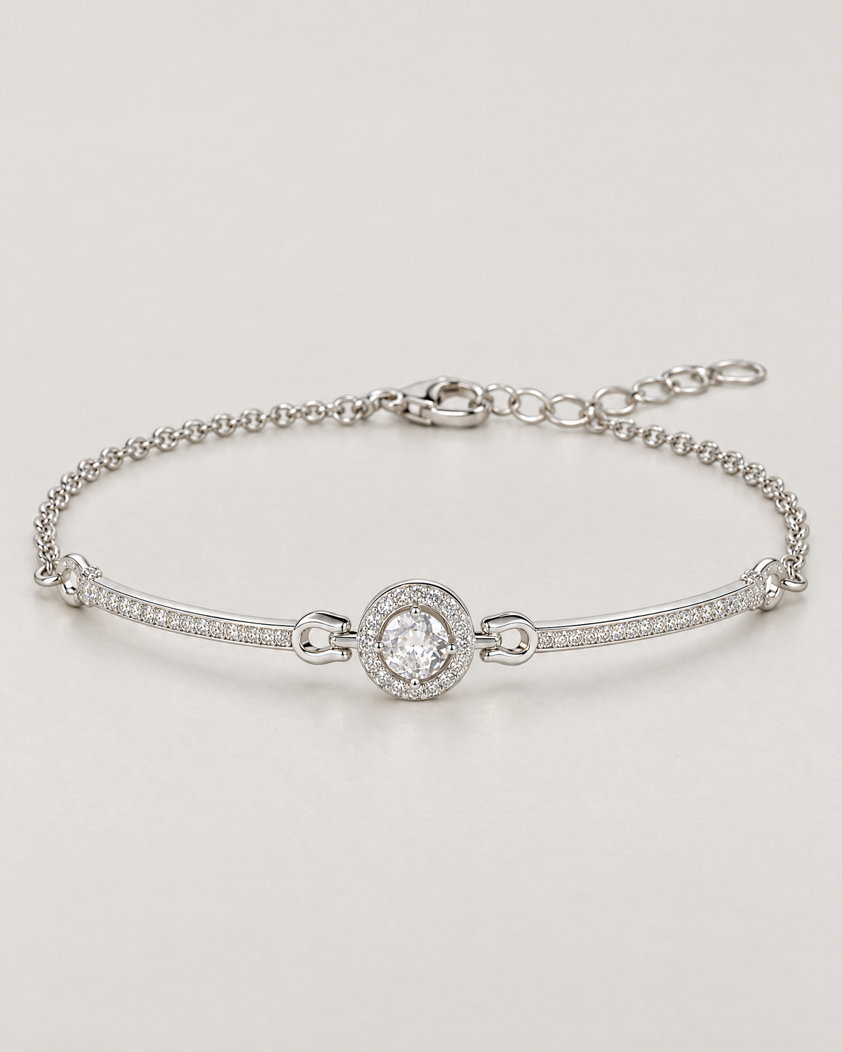 The Sora Halo Bracelet polished cool silver-tone complete low-angle resting lay with clear-stone halo, slender curved stone-set bars and chain extension on pale greige reference-based AI visualization