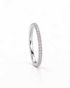 The Vale CZ Eternity Band — bright polished silver-tone clear-stone eternity band in a side setting profile on a pearl-white studio background, reference-based AI visualization