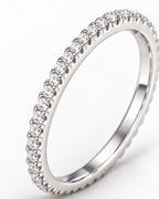 The Vale CZ Eternity Band — bright polished silver-tone clear round stones and raised-prong setting macro on a pearl-white studio background, reference-based AI visualization