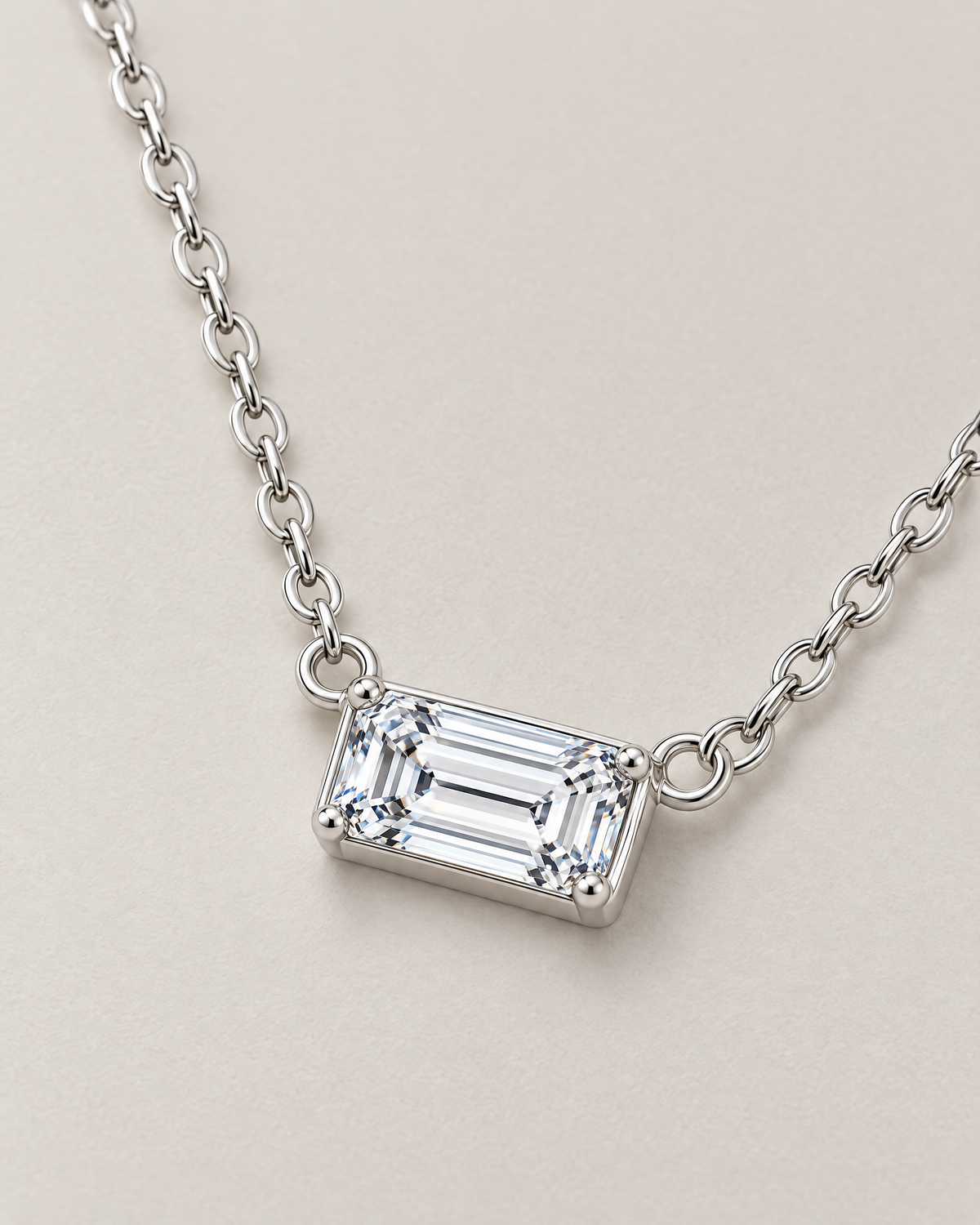 The Mara Geometric CZ Pendant — jewelry-only three-quarter view of the horizontal clear rectangular stone, four corner prongs, side rings, and alternating-link chain on pale warm greige; reference-based AI visualization